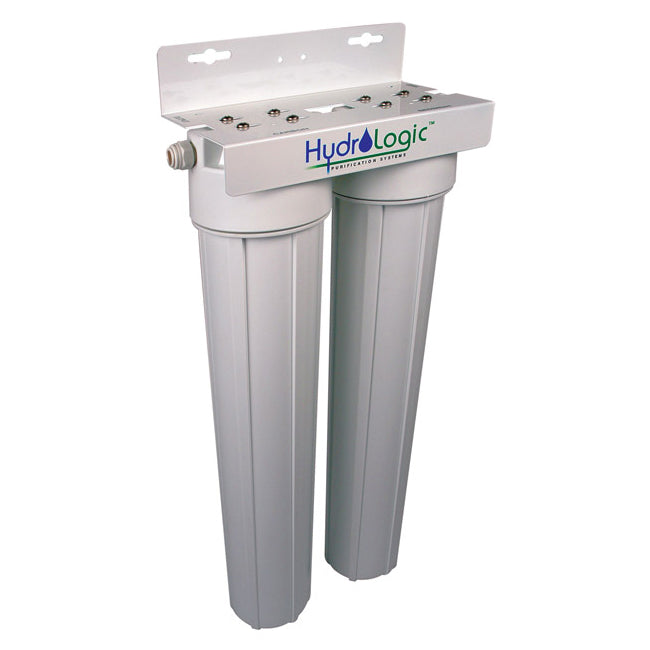 A white, dual-chamber Hydrologic Tall Boy Dechlorinator & Sediment Water Filter by TAS with long cylindrical filters incorporating KDF85 filtration media, mounted on a metal bracket.
