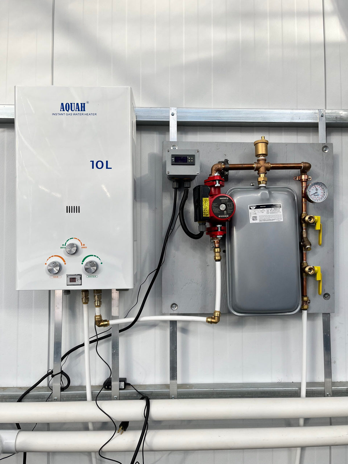 AquaHeat Propane or Natural Gas Fired Heating System, a TAS heating system, is connected to a pipe in a building.