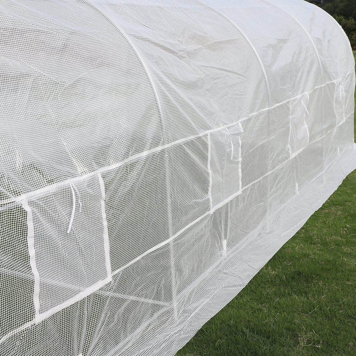 An Outsunny 20&#39; x 10&#39; x 7&#39; Deluxe High Tunnel Walk-in Garden Greenhouse Kit - White, perfect for growing plants and crops, in a grassy field.