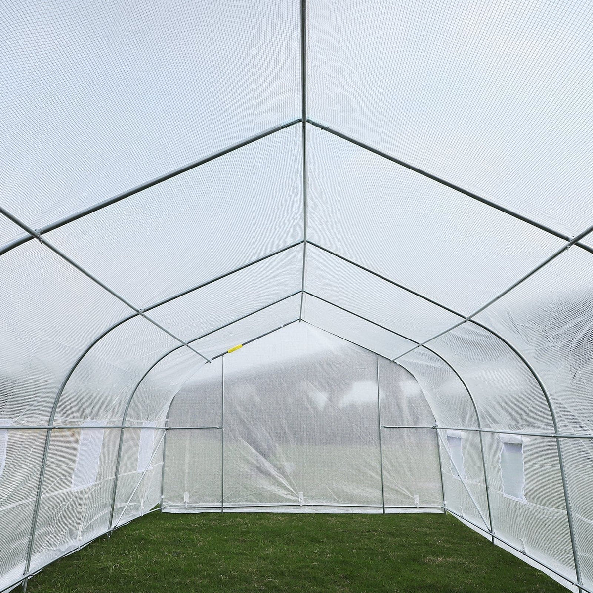 A greenhouse filled with lush plants and thriving crops, all protected by an Outsunny 20&#39; x 10&#39; x 7&#39; Deluxe High Tunnel Walk-in Garden Greenhouse Kit - White from Aosom.