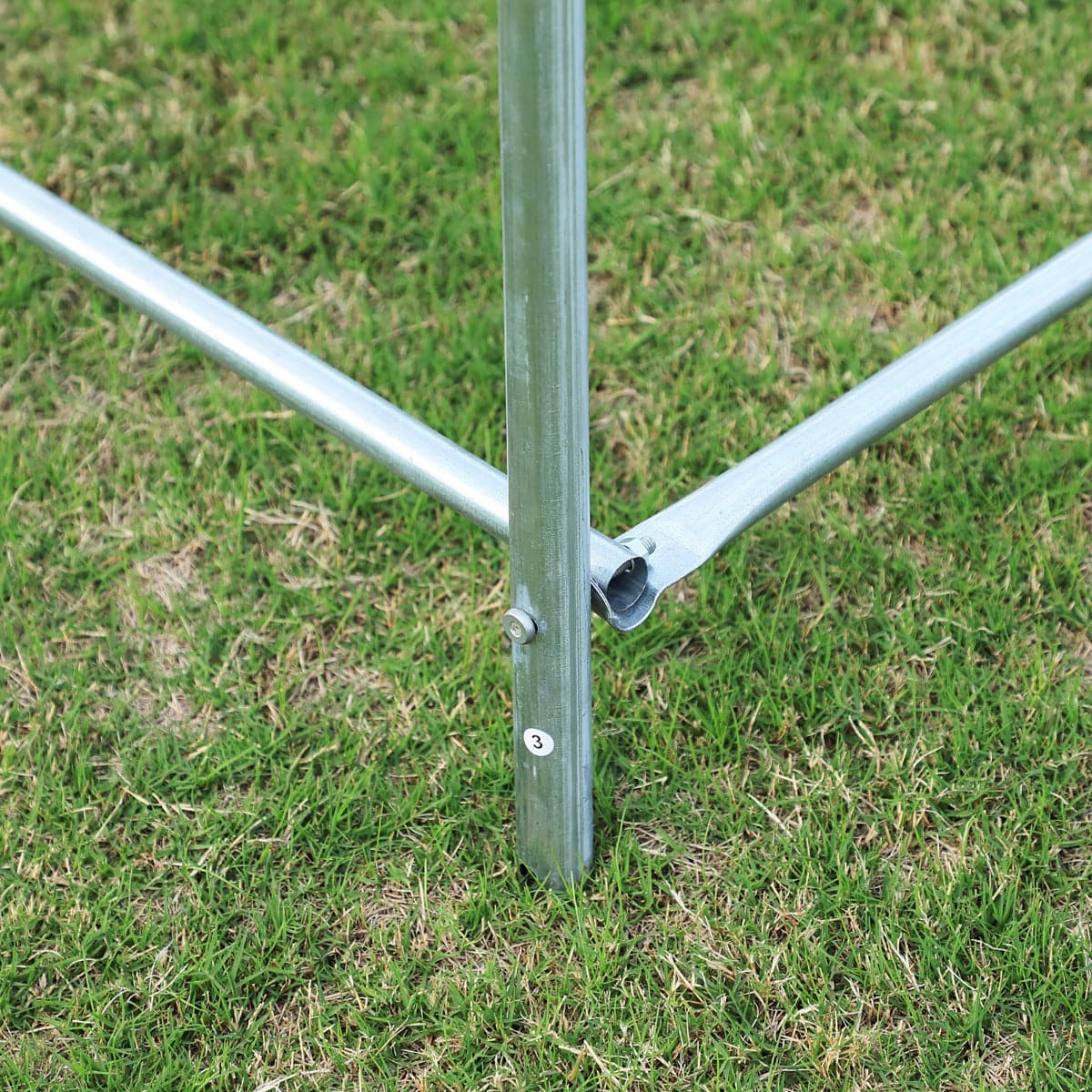 A close up of a metal pole standing on grass near an Aosom Outsunny 20&#39; x 10&#39; x 7&#39; Deluxe High Tunnel Walk-in Garden Greenhouse Kit - White.