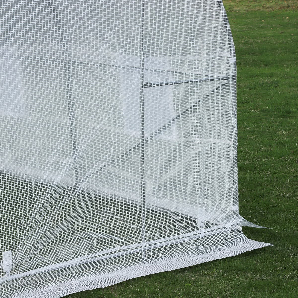 An Aosom Outsunny 20&#39; x 10&#39; x 7&#39; Deluxe High Tunnel Walk-in Garden Greenhouse Kit - White with crops and plants on a grassy field.